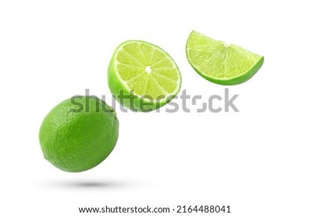 Whole, half and slice fresh lime fruit falling in the air isolated on white background.