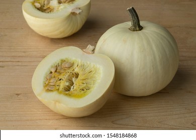Whole and halved fresh white Lumina pumpkins with seeds 