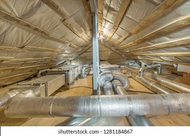 Lüftungs- und Reinigungssystem des ganzen Hauses. Lüftungsrohre in silbernem Isoliermaterial auf dem Dachboden