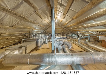Whole house air ventilation and cleaning system. Ventilation pipes in silver insulation material on the attic