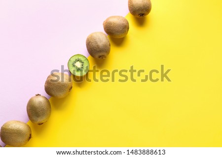 Whole kiwifruits and one half on color background. Concept of uniqueness