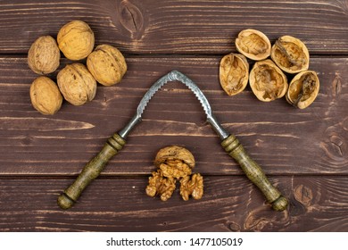 Lot Of Whole Lot Of Pieces Of Ripe Brown Walnut With Old Nutcracker Flatlay On Brown Wood