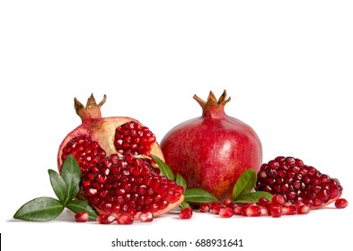 whole Pomegranates and three parts of Pomegranate with leaves and seeds isolated on white