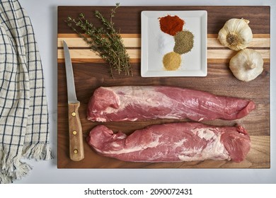 Whole Pork Tenderloin With Garlic, Thyme And Spices On A Cutting Board Being Prepared For Cooking