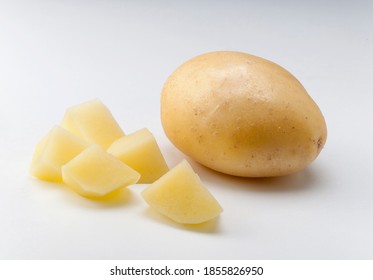 whole potato with skin and diced on white background