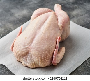 Whole raw chicken on white paper. Preparing raw chicken. - Shutterstock ID 2169784211
