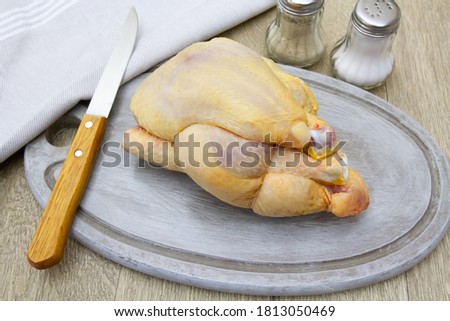 whole raw guinea fowl on a cutting board