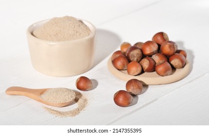 Whole Raw Hazelnuts And Hazelnut Flour On White Wooden Table. Paleo An Ketogenic Diet Baking, Keto Cooking, Gluten Free Food