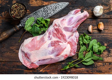 Whole Raw lamb shoulder leg meat with garlic, mint. Dark wooden background. Top view - Powered by Shutterstock