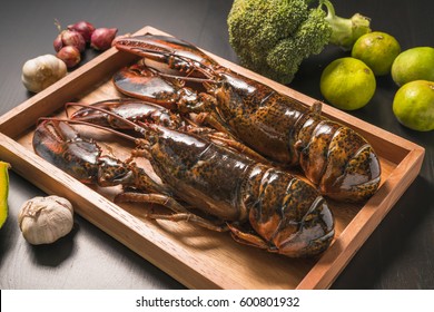 Whole raw lobster. Raw lobster on wooden plate. raw canadian lobster crayfish on wooden plate.