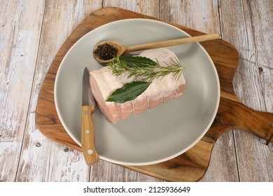 Whole Raw Pork Roast In A Dish On A Wooden Board 