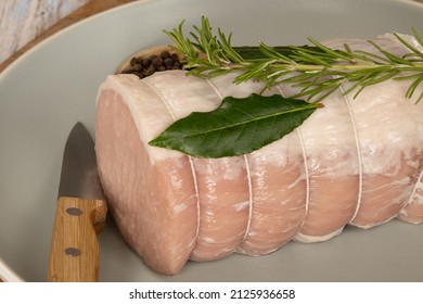 Whole Raw Pork Roast In A Dish On A Wooden Board 