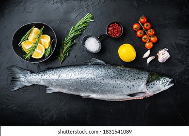 Whole raw salmon on black background, top view