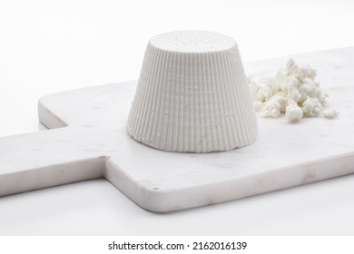 Whole Ricotta Cheese On A White Marble Cutting Board