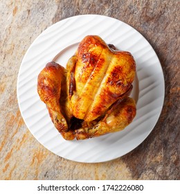 Whole Roast Chicken Served On A White Plate On A Stone Table, Flat Lay, Close-up