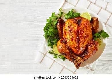 Whole Roast Chicken, Turkey With Rosemary, Mint, Parsley And Lime On A White Plate On A Wooden Table, Horizontal View From Above, Flat Lay, Free Space