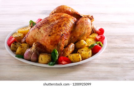 Whole Roast Spicy Chicken With Potatoes, On Plate Over Wooden Background