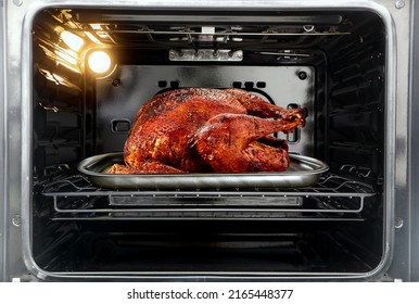 Whole roast turkey in the oven - Shutterstock ID 2165448377