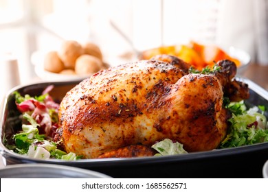 Whole roasted chicken with fresh salad in black dish
