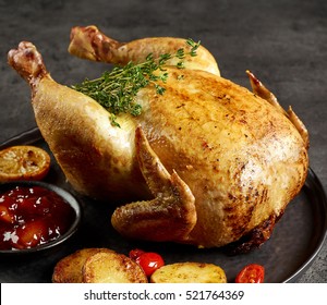 whole roasted chicken on dark grey kitchen table