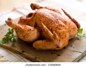 Whole roasted chicken on wooden board, selective focus 