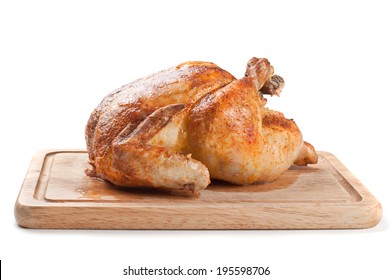 Whole roasted chicken on wooden board