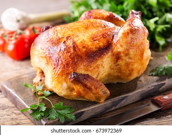 whole roasted chicken on a wooden board