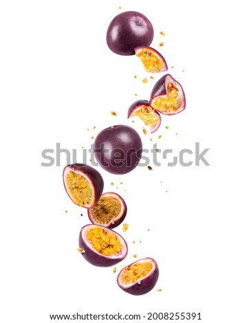 Whole and sliced fresh passion fruit (passiflora) in the air on a white background