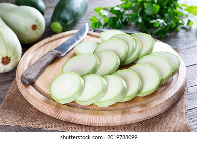 Whole and sliced fresh zucchini on wooden table. Healthy vegetarian ingredient - Shutterstock ID 2019788099