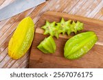 Whole and sliced fruits fresh carambola on wooden table. Healthy vegetarian ingredient