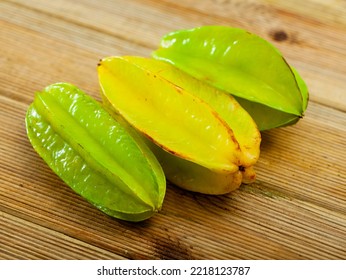 Whole and sliced fruits fresh carambola on wooden table. Healthy vegetarian ingredient - Shutterstock ID 2218123787
