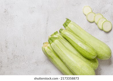Whole and slices of  fresh vegetable marrow on light background. Vegetarian organic vegetables.Healthy food.Copy space.Place for text