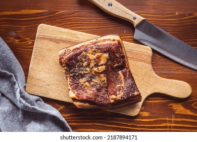 Whole Smoked Bacon On A Cutting Board. Top View.