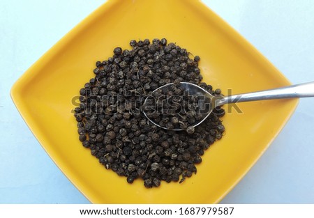 Whole spice black peppers in a bowl. 