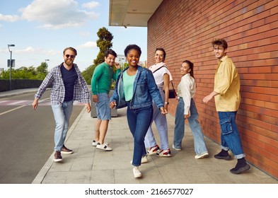 Whole Squad Back In Town. Bunch Of Happy Young Diverse Friends Walking On The Street Together. Group Of Joyful Beautiful African American, Asian And Caucasian People Enjoying Friendly Summer Hangout