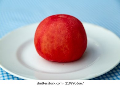 Whole Tomato Without Peel On A White Earthenware Plate