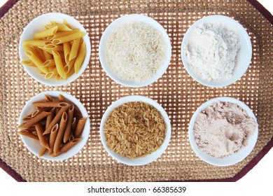 Whole Wheat And Brown Rice Versus White Pasta, Flour And Rice On A Table Mat In  Bowls