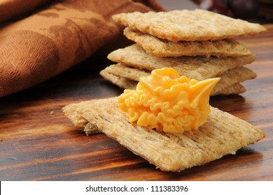 A Whole Wheat Cracker Topped With Cheddar Cheese Spread