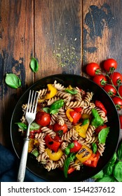 Whole Wheat Fusilli Pasta With Grilled Vegetables In A Black Bowl On A Wooden Background. Top View With Copy Space.