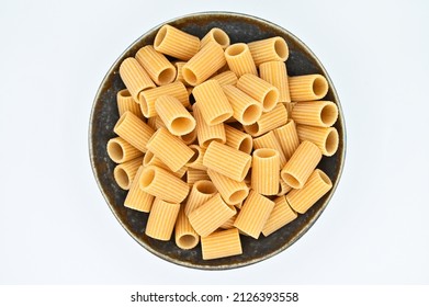 Whole Wheat Mezze Rigatoni Pasta, In A Dark Grey Bowl, Isolated On A White Background