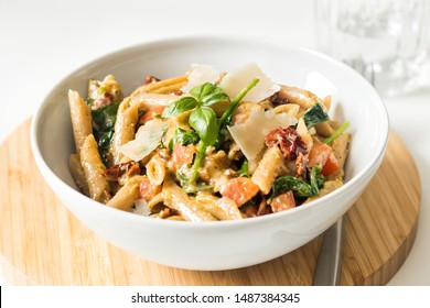 Whole Wheat Pasta With Dried Tomatoes, Basil And Parmesan In White Bowl