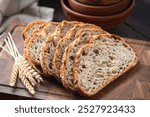 Whole wheat sourdough bread sliced on a wooden cutting board, closeup view. Healthy bread choice