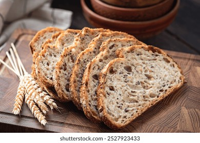 Whole wheat sourdough bread sliced on a wooden cutting board, closeup view. Healthy bread choice - Powered by Shutterstock