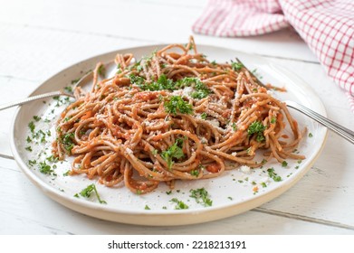 "Whole wheat"spaghetti with homemade tomato sauce and parmesan cheese on a plate isolated on white wooden background - Powered by Shutterstock