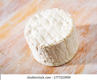 Whole wheel of piquant creamy blue cheese on wooden surface - Powered by Shutterstock