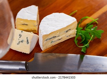 Whole Wheel Of Piquant Creamy Blue Cheese On Wooden Cutting Board