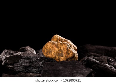 Whole white truffles on black background with reflection. Luxurious culinary cooking ingredients.