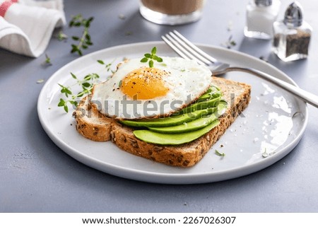 Wholegrain avocado toast with fried egg on top, healthy breakfast idea