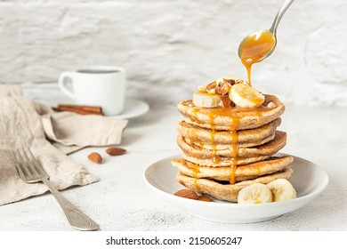 Wholegrain pancakes with banana and caramel sauce. Delicious breakfast.