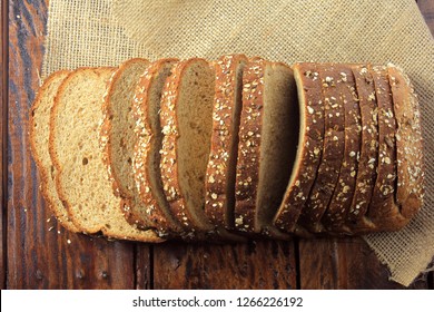 Wholegrain sliced organic bread composed of oats and flax seeds on wooden table. Healthy Diet.Top view - Shutterstock ID 1266226192